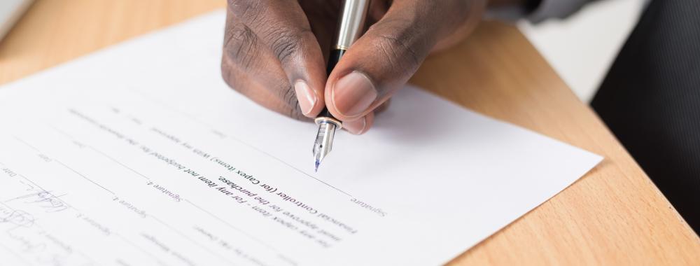 male hand filling out a form with a pen